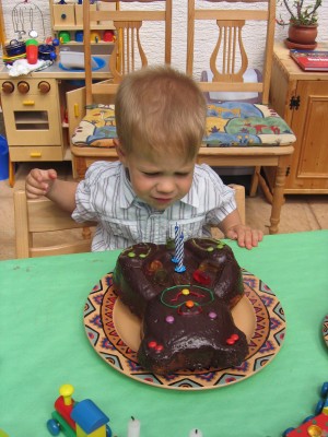 Das Geburtstagskind beim auspusten der Kerzen, des traditionellen Bärchenkuchens